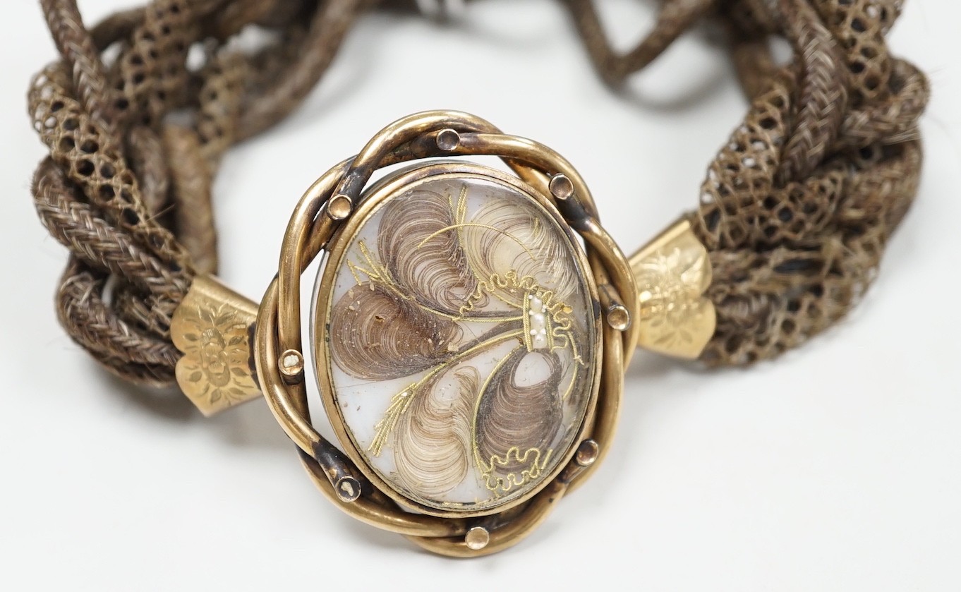 A 19th century gilt metal and plaited hair set interwoven hair mourning bracelet, central motif 41mm by 33mm.